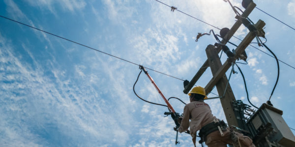 The power lineman closing a transformer on energized high-voltage electric power lines.